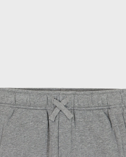 Close-up of gray sweatpants with a drawstring on a light gray background