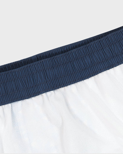 Close-up of white shorts with a navy waistband on a light gray background